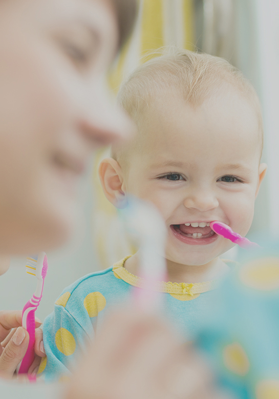 Pediatric Dentist Coquitlam 4 Young child smiling while brushing teeth